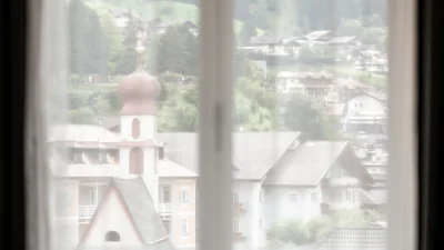 Window view from the living area of apartment Saslonch in Ortisei towards the Church of St. Anthony
