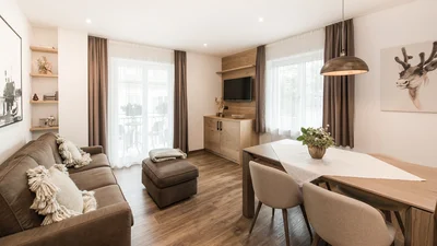 Living area with dining table, window, and balcony door of the apartment Seceda in Ortisei