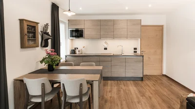 Kitchen and dining table of the living area of the apartment Saslonch in Ortisei 