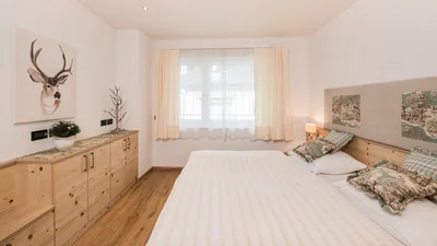 Double bedroom with window of apartment Resciesa in Ortisei