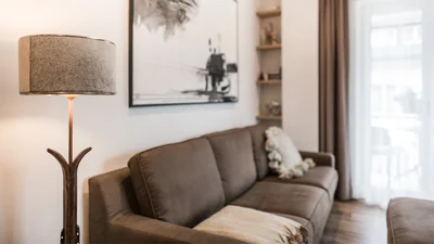 Couch and balcony door of the living area of the apartment Seceda in Ortisei 
