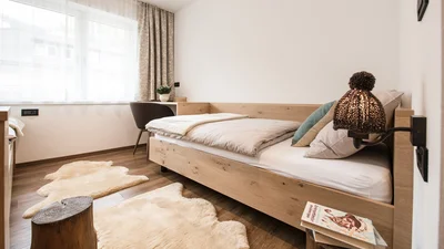 Bed and window of the twin bedroom of the apartment Seceda in Ortisei
